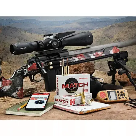 A picture of some 109 ELD Match Ammo next to a rifle